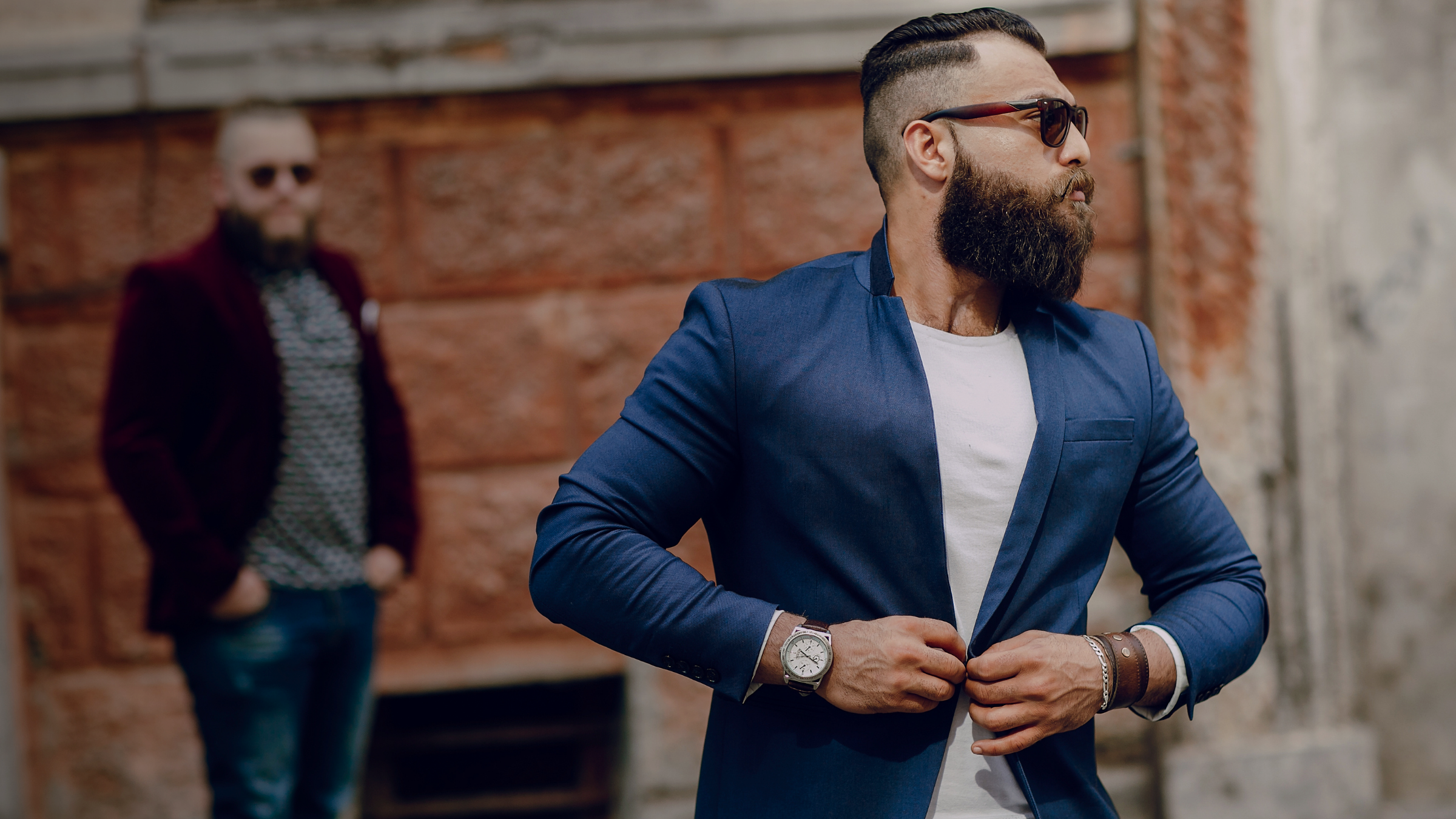 Confident man in blue blazer walking urban street golden hour